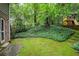 Sprawling backyard with mature trees and a playground perfect for outdoor fun and recreation at 220 N Springs Ct, Sandy Springs, GA 30328