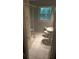 Neutral bathroom featuring a shower, toilet, and large window offering natural light at 220 N Springs Ct, Sandy Springs, GA 30328