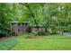Charming home featuring a lush green lawn and mature trees for a private setting at 220 N Springs Ct, Sandy Springs, GA 30328