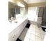 Bright bathroom featuring a double vanity, bathtub, and a separate glass-enclosed shower for convenience at 2532 Greenes Ln, Powder Springs, GA 30127