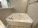 Bathroom features a jacuzzi tub with tile surround and neutral walls at 790 Village Field Ct, Suwanee, GA 30024