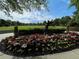 Well-manicured floral garden at a common area featuring a statue and treeline backdrop at 790 Village Field Ct, Suwanee, GA 30024