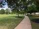 Sidewalk path along a green common area and mature trees in residential neighborhood at 790 Village Field Ct, Suwanee, GA 30024