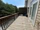 Exterior deck featuring a weathered wood floor and dark brown wood railing with trees in the background at 790 Village Field Ct, Suwanee, GA 30024