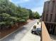 Exterior view from wood deck featuring a tree-lined street, parked car, and a black car in the driveway at 790 Village Field Ct, Suwanee, GA 30024