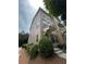 Three-story townhouse with well-manicured bushes, a cozy front porch, and neutral siding at 790 Village Field Ct, Suwanee, GA 30024