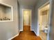 Hallway with hardwood floors, neutral walls, and a bathroom view at 790 Village Field Ct, Suwanee, GA 30024