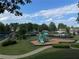 Community playground with slides, swings, and a climbing structure surrounded by green space at 790 Village Field Ct, Suwanee, GA 30024