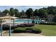 Community pool featuring lounge chairs and umbrellas alongside green space and playground at 790 Village Field Ct, Suwanee, GA 30024