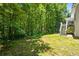 Side view of backyard with wooden staircase leading to deck among lush green trees at 1294 Red Rock Rd, Acworth, GA 30101