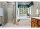 Bathroom with a luxurious soaking tub, large window, and a glass-enclosed shower for relaxation at 1294 Red Rock Rd, Acworth, GA 30101
