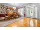 Dining room featuring hardwood floors, a large dining table, a china cabinet, and floral wallpaper at 1294 Red Rock Rd, Acworth, GA 30101