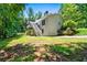 View of the back exterior featuring a two-story home, wooden deck, and a lush, wooded lot at 1294 Red Rock Rd, Acworth, GA 30101