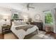 Bright bedroom featuring a ceiling fan, two windows, hardwood floors and a wooden bed frame at 2316 Hurst Ne Dr, Atlanta, GA 30305