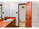Bathroom with orange countertop, modern faucet, and a rustic wooden door leading to the shower at 2420 Leaf Land Dr, Duluth, GA 30097