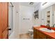 Cozy bathroom with orange countertop, modern fixtures, and decorative shelving for added storage at 2420 Leaf Land Dr, Duluth, GA 30097
