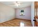 Bright bedroom with laminate floors, a modern ceiling fan, natural light, and a classic wooden door at 2420 Leaf Land Dr, Duluth, GA 30097
