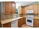 Kitchen featuring wood cabinets, butcher block counters, white appliances, and backsplash at 2420 Leaf Land Dr, Duluth, GA 30097