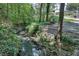 Scenic view of a creek flowing through a lush landscape, with stone accents and dense foliage at 3203 Lenox Ne Rd # 22, Atlanta, GA 30324