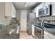 Well-lit kitchen featuring granite counters, stainless appliances, mosaic backsplash, and white cabinets at 3203 Lenox Ne Rd # 22, Atlanta, GA 30324