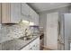 Bright kitchen featuring stainless appliances, granite counters, mosaic backsplash, and white cabinets at 3203 Lenox Ne Rd # 22, Atlanta, GA 30324