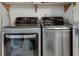 Laundry room featuring front-load washer and dryer in stainless steel and a rustic wooden shelf above at 3203 Lenox Ne Rd # 22, Atlanta, GA 30324