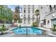 Resort-style swimming pool surrounded by lounge chairs, landscaping, and a modern building facade at 3203 Lenox Ne Rd # 22, Atlanta, GA 30324