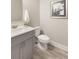 Neutral half bathroom with gray vanity, white sink, toilet, and stylish framed art at 3794 Jack Vernon Cir, Powder Springs, GA 30127