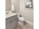 Cozy half bathroom featuring gray vanity with white countertop and a white toilet on hardwood floors at 3794 Jack Vernon Cir, Powder Springs, GA 30127