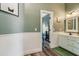 Bathroom with wainscoting, framed mirror, and doorway leading into adjacent bedroom at 6740 Mountain Lake Ln, Cumming, GA 30028