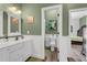 Well-lit bathroom features a double sink vanity, wood floors and an adjacent commode at 6740 Mountain Lake Ln, Cumming, GA 30028