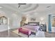 Large bedroom with tray ceilings, light hardwood floors, and a gold framed mirror at 6740 Mountain Lake Ln, Cumming, GA 30028