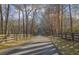 Long winding driveway lined with wooden fencing and mature trees at 6740 Mountain Lake Ln, Cumming, GA 30028