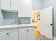 Bright laundry room with white cabinets and a marble countertop at 6740 Mountain Lake Ln, Cumming, GA 30028