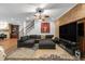 Open-concept living room features a large sectional sofa, brick wall, and stylish rug at 6740 Mountain Lake Ln, Cumming, GA 30028