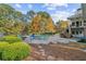 Backyard pool surrounded by lush greenery, trees, and patio with a deck above at 6740 Mountain Lake Ln, Cumming, GA 30028