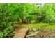 An arched wooden bridge leads to a lush, verdant backyard setting at 10490 Cranchester Way, Alpharetta, GA 30022