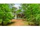 Lush backyard featuring a house with multiple decks, surrounded by mature trees at 10490 Cranchester Way, Alpharetta, GA 30022
