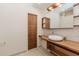 Modern bathroom featuring a unique vessel sink, wood countertop, and sleek wooden door at 10490 Cranchester Way, Alpharetta, GA 30022