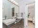 Modern bathroom features a double vanity, vessel sinks, large mirror, and views to the primary bedroom at 10490 Cranchester Way, Alpharetta, GA 30022