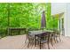 Outdoor dining on spacious wooden deck with umbrella and iron table surrounded by nature at 10490 Cranchester Way, Alpharetta, GA 30022