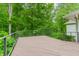 Wooden deck with metal railing providing scenic views of the surrounding trees at 10490 Cranchester Way, Alpharetta, GA 30022