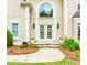 Close-up of the front entrance features a stone walkway, double doors with floral wreaths, and stylish exterior lighting at 10490 Cranchester Way, Alpharetta, GA 30022