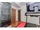 Home gym with a treadmill and glass-enclosed storage cabinet at 10490 Cranchester Way, Alpharetta, GA 30022