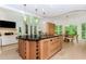 Kitchen featuring center island with bar seating adjacent to living room with fireplace and wooded view at 10490 Cranchester Way, Alpharetta, GA 30022