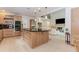 Kitchen featuring center island with bar seating adjacent to living room with fireplace at 10490 Cranchester Way, Alpharetta, GA 30022