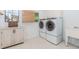 Well-equipped laundry room with cabinetry, utility sink, and washer/dryer at 10490 Cranchester Way, Alpharetta, GA 30022