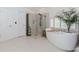 Spa-like bathroom featuring a soaking tub, tiled shower, and modern fixtures at 10490 Cranchester Way, Alpharetta, GA 30022