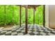 Covered stone patio featuring a checkered pattern and tranquil woodland views at 10490 Cranchester Way, Alpharetta, GA 30022