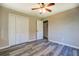 Neutral bedroom features wood-look floors, closet with doors, and a ceiling fan at 14721 Highway 36, Covington, GA 30014